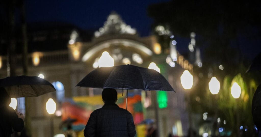 imagem de uma pessoa caminhando na chuva com um guarda chuva para falar sobre o  Tempo severo no Rio Grande do Sul