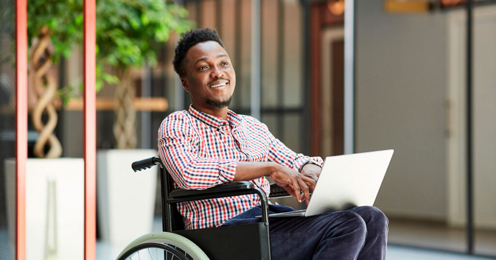 homem cadeirante com o notebook no colo para falar sobre o auxílio-inclusão