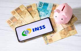 imagem com o celular com o logo do INSS , dinheiro e um porquinho de cofrinho para falar do 13º salário do INSS