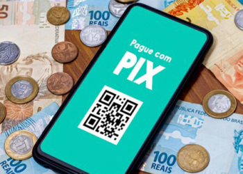 imagem mostra um celular em cima de dinheiro para falar sobre o Pix Automático