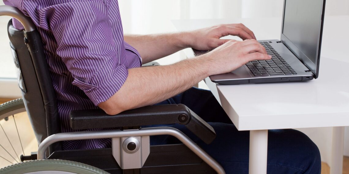 imagem com uma pessoa cadeirante, trabalhando, para falar do Auxílio-inclusão