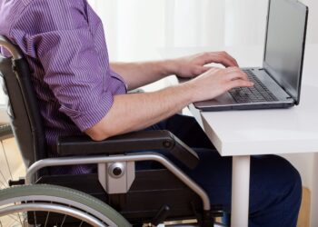 imagem com uma pessoa cadeirante, trabalhando, para falar do Auxílio-inclusão