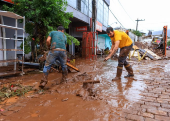 dois homens limpando as ruas em uma cidade do RS