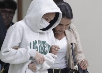 imagem de uma das possíveis participantes do crime, usando capuz branco e mascara
