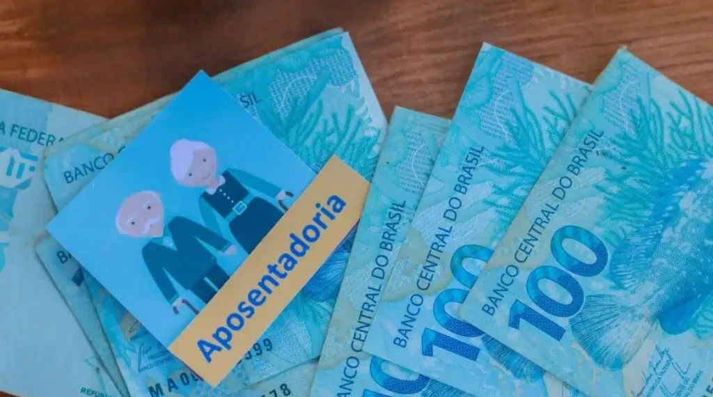 imagem mostra desenho de idosos com cédulas de 100 reais