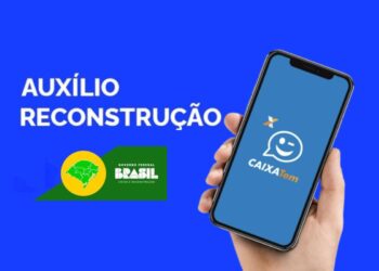 imagem com fundo azul, uma pessoa segurando um celular com o app do Caixa Tem aberto para mostrar onde receber o Auxílio Reconstrução.